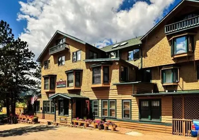 a large wooden building with flowers in front of it at Diamond - The Historic Crags Lodge - 1BD in Estes Park