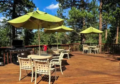 a patio with tables and chairs with umbrellas at Diamond - The Historic Crags Lodge - 1BD in Estes Park