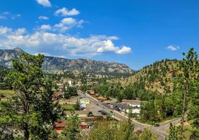 a town with a road and mountains in the background at Diamond - The Historic Crags Lodge - 1BD in Estes Park