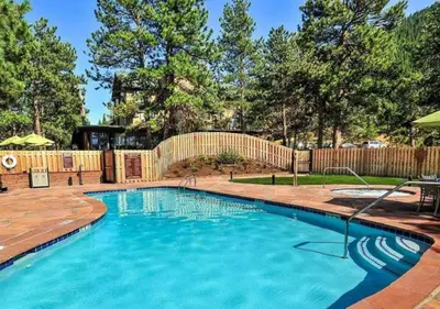 a swimming pool in a backyard with a wooden fence at Diamond - The Historic Crags Lodge - 1BD in Estes Park