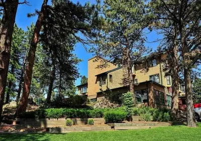 a large yellow house with trees at Diamond - The Historic Crags Lodge - 2BD in Estes Park