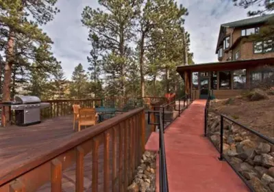 a wooden deck with a grill on a house at Diamond - The Historic Crags Lodge - 2BD in Estes Park