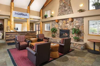 a lobby with chairs and a stone fireplace at Worldmark - Estes Park 1BD in Estes Park