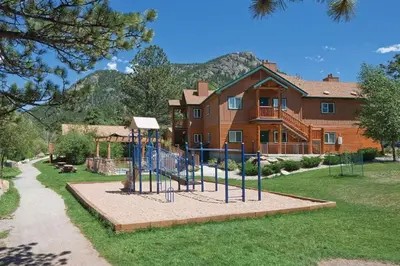 a playground in front of a large house at Worldmark - Estes Park 2BD in Estes Park