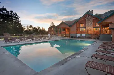a large swimming pool with chairs and a house at Worldmark - Estes Park 2BD in Estes Park