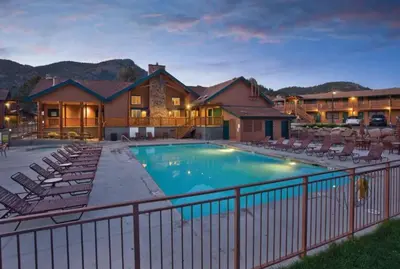 a large swimming pool with chairs and a house at Worldmark - Estes Park 2BD in Estes Park
