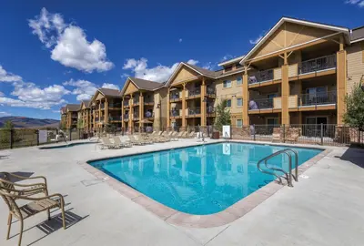 a swimming pool at a resort with chairs and a building at Worldmark Granby Rocky Mountain 1BD in Granby
