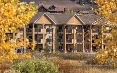 a large apartment building with a mountain in the background at Worldmark Granby Rocky Mountain 2BD in Granby