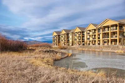 a resort with a river in front of a building at Worldmark Granby Rocky Mountain 2BD in Granby