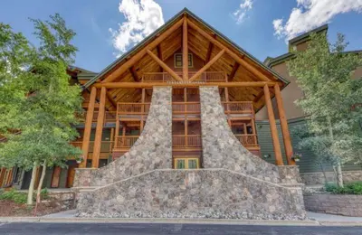 a large wooden house with a stone staircase in front of it at Tenderfoot Lodge 2 Bedroom At The Mountain House Base in Keystone