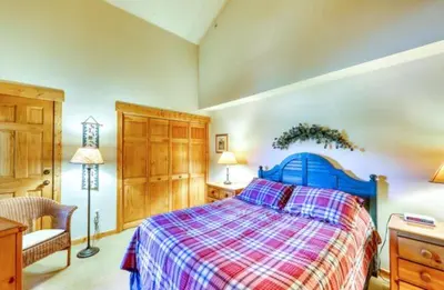 a bedroom with a blue bed with a plaid blanket at Tenderfoot Lodge 1 Bedroom At The Mountain House Base in Keystone