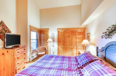 a bedroom with a bed and a tv on a dresser at Tenderfoot Lodge 1 Bedroom At The Mountain House Base in Keystone