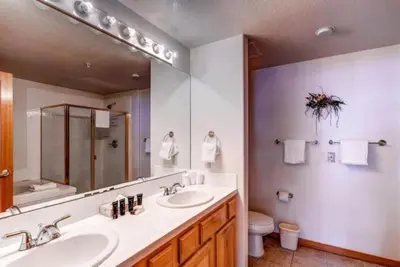 a bathroom with two sinks and a large mirror at 2 Bedroom Gateway Lodge Condo Near Mountain House in Keystone