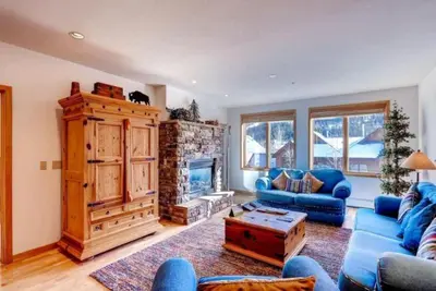 a living room with a blue couch and a fireplace at 2 Bedroom Gateway Lodge Condo Near Mountain House in Keystone