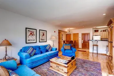 a living room with a blue couch and a table at 2 Bedroom Gateway Lodge Condo Near Mountain House in Keystone