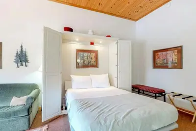 a bedroom with a bed and a blue couch at Studio Condo At Gateway Lodge In Keystone in Keystone