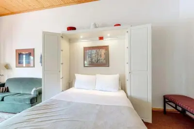 a bedroom with a white bed and a blue couch at Studio Condo At Gateway Lodge In Keystone in Keystone