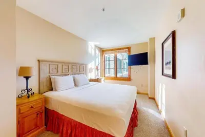 a bedroom with a large white bed and a window at Dakota Lodge 2 Bedroom Condo In River Run Village in Keystone