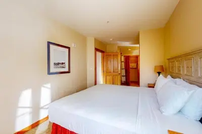 a bedroom with a large bed with white pillows at Dakota Lodge 2 Bedroom Condo In River Run Village in Keystone
