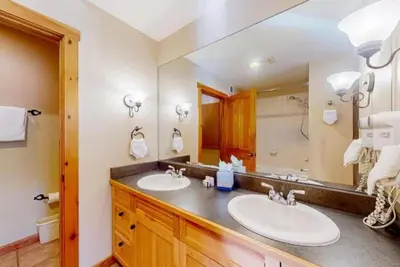 a bathroom with two sinks and a large mirror at Dakota Lodge 2 Bedroom Condo In River Run Village in Keystone