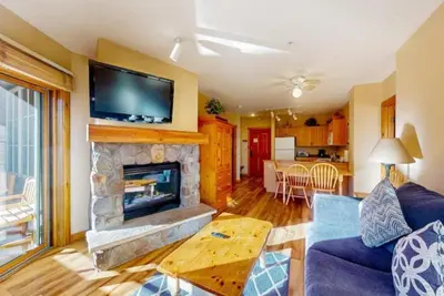 a living room with a fireplace and a tv on the wall at Dakota Lodge 2 Bedroom Condo In River Run Village in Keystone