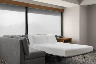 a bed and a chair in a room with a window at Hyatt Place Denver Cherry Creek in Denver