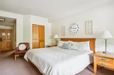 a bedroom with a bed and a clock on the wall at Cozy Ski-In Ski-Out Condo with Heated Pool in Keystone