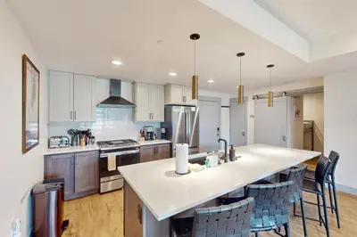 a kitchen with a large island with bar chairs at Timber Fox Escape in Winter Park