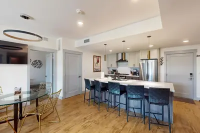 a kitchen with a bar with chairs and a table at Timber Fox Escape in Winter Park