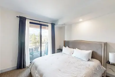 a bedroom with a bed and a large window at Timber Fox Escape in Winter Park