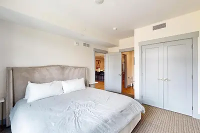 a bedroom with a large bed with white sheets at Timber Fox Escape in Winter Park