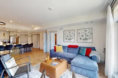 a living room with a blue couch and a kitchen at Timber Fox Escape in Winter Park