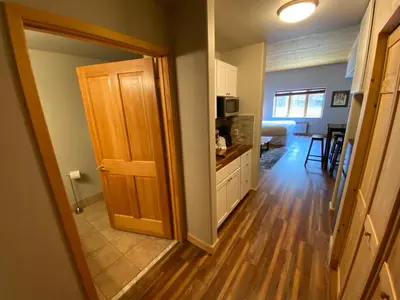 a kitchen and living room with a wooden door at Gateway Lodge 5003 by SummitCove Lodging in Keystone