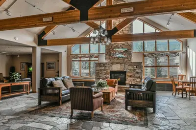an open living room with a stone fireplace at Gateway Lodge 5003 by SummitCove Lodging in Keystone