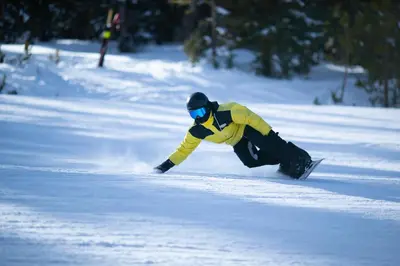 a man riding a snowboard down a snow covered slope at Ski Tip 8709 : 2 in Keystone