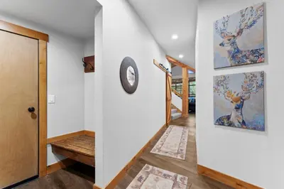a hallway with white walls and a door with a clock at Ski Tip 8709 : 2 in Keystone