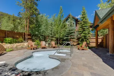 a swimming pool in a yard with chairs and a house at Ski Tip 8709 : 2 in Keystone