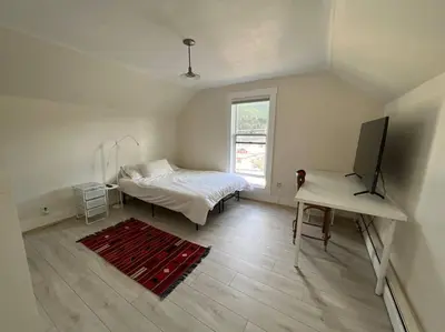 a bedroom with a bed and a tv and a table at 3 Bedroom - Awesome Views, Light, Deck in Idaho Springs
