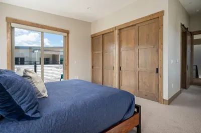 a bedroom with a large bed and a large wooden door at Aprez Retreat condo in Winter Park