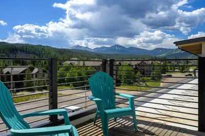 two chairs on a deck with a view of mountains at Aprez Retreat condo in Winter Park