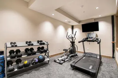 a room with a gym with a treadmill and a television at Aprez Retreat condo in Winter Park
