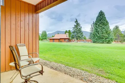 a chair sitting on a porch with a grass field at Steps to Shadow Mountain Lake Grand Lake Condo in Grand Lake