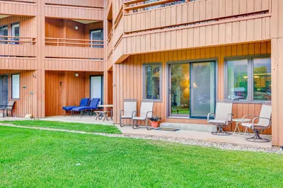 a patio with chairs and tables next to a building at Steps to Shadow Mountain Lake Grand Lake Condo in Grand Lake