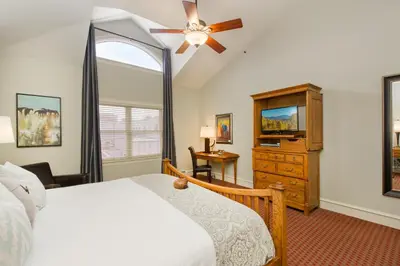 a bedroom with a bed and a dresser and a tv at The Bradley Boulder Inn in Boulder
