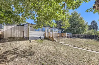 a cabin in a yard with a fence at 4BD - Hot Tub, BBQ, Games - 10 Mins to Olde Town in Arvada