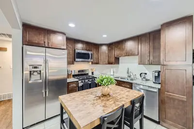 a kitchen with stainless steel appliances and a table with chairs at 4BD - Hot Tub, BBQ, Games - 10 Mins to Olde Town in Arvada