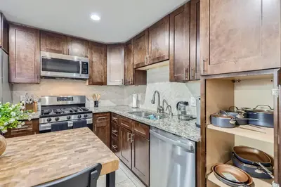 a kitchen with wooden cabinets and a counter top at 4BD - Hot Tub, BBQ, Games - 10 Mins to Olde Town in Arvada
