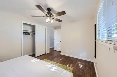 a white bedroom with a ceiling fan and a window at 4BD - Hot Tub, BBQ, Games - 10 Mins to Olde Town in Arvada