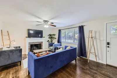 a living room with a blue couch and a fireplace at 4BD - Hot Tub, BBQ, Games - 10 Mins to Olde Town in Arvada