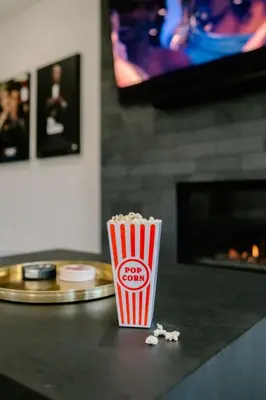 a cup of popcorn sitting on a table with a tv at Cloud N9NE Chalet in Fraser